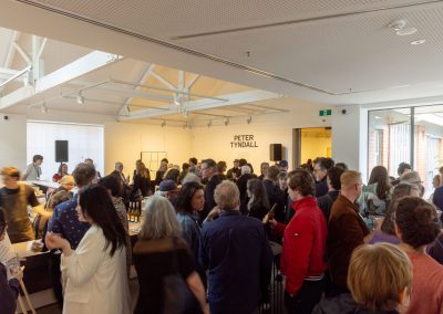 A room of people enjoying the opening of Peter Tyndall with drinks and canapes