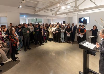 Rose Hiscock speaks at a lectern in front of a room of people at Buxton Event Gallery drinks