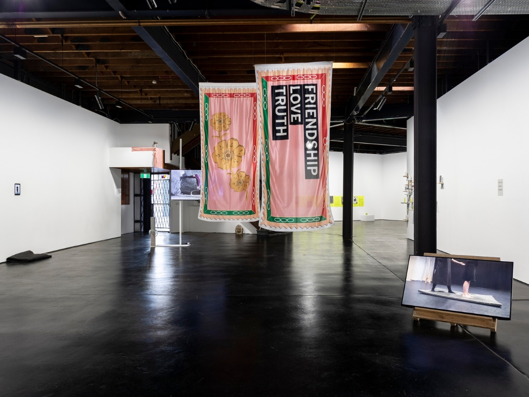 the interior of a gallery with banners hanging from the ceiling