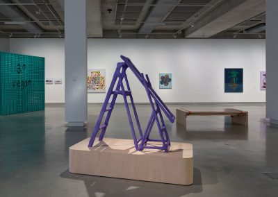 the interior of a contemporary art gallery with a sculpture in the foreground and paintings on the wall