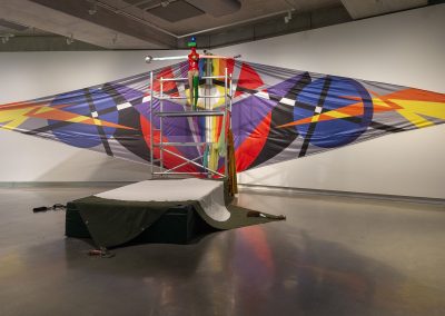 A colourful kite on a wall in a gallery